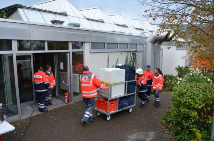 Helfer des Deutschen Roten Kreuzes und des Malteser Hilfsdienstes bringen bei der Katastrophenschutzübung Materialien für die Notfallunterbringung Evakuierter in die Turnhalle der BBS Bingen. (Foto: Kreisverwaltung Mainz-Bingen)