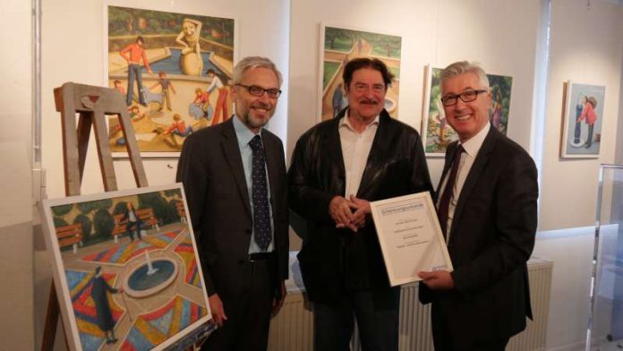 Prof. Dr. Matthias Maier (links) und Dr. Karl Roth (rechts) überreichen dem Künstler Benno Huth die Schenkungsurkunde. Im Hintergrund sind einige der Werke des Künstlers zu sehen. (Foto: Stadtwerke)