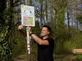 Peter Niklaus vom Odenwaldklub bringt die neuen Hinweistafeln an (Foto: Roland Robra)