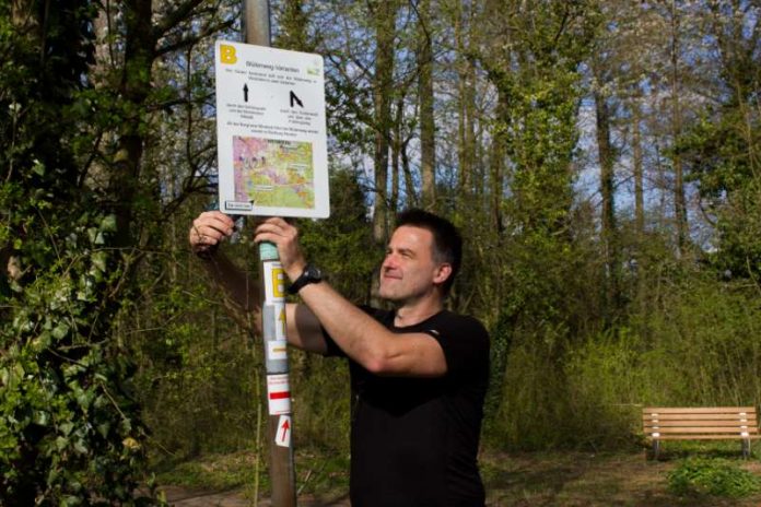 Peter Niklaus vom Odenwaldklub bringt die neuen Hinweistafeln an (Foto: Roland Robra)