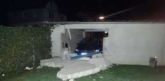 Beschädigte Garage mit Unfall-PKW